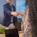 Business man shake hands with business women agreeing on partnerships or introducing themselves