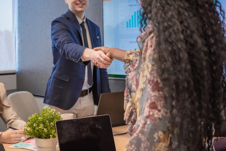Business man shake hands with business women agreeing on partnerships or introducing themselves